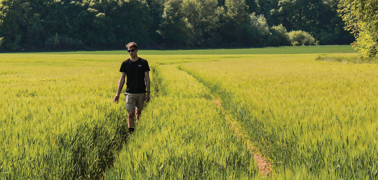 Man walking through field.