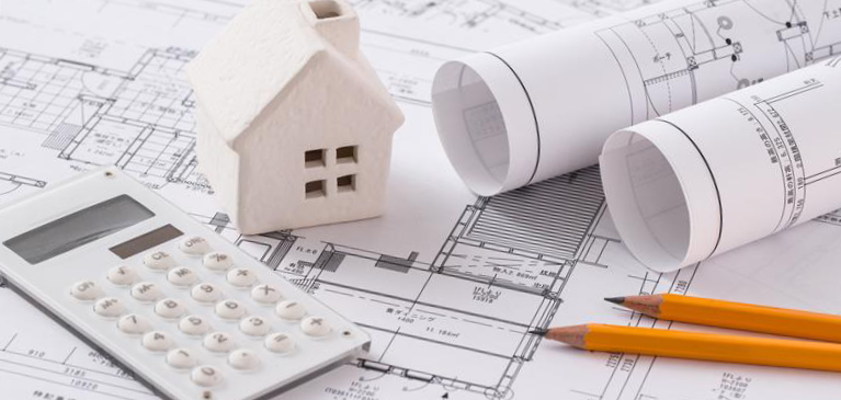 Home plans laid out with a calculator and pencils