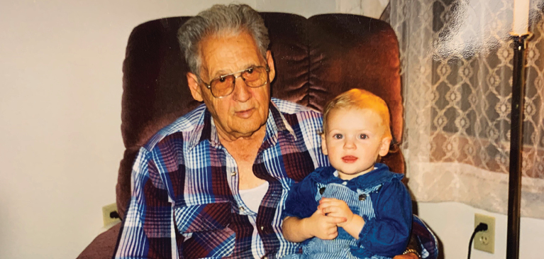 Emily sits on her grandfather lap as a young child. 