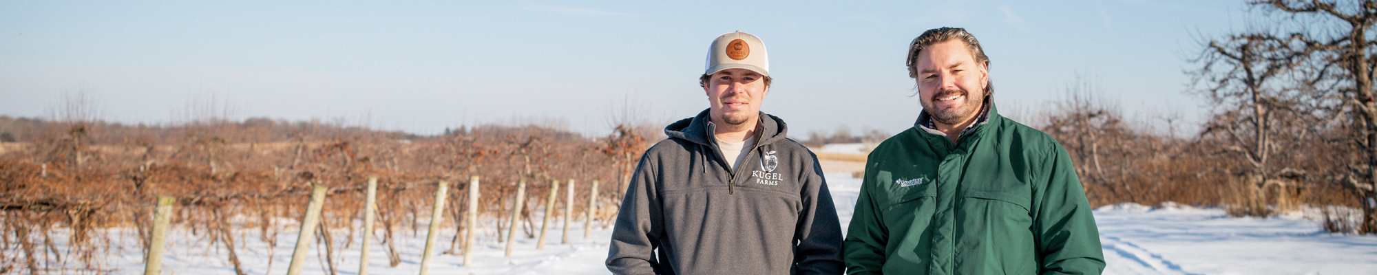 Two men in a winery field in the snow