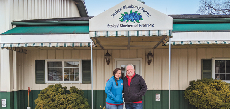 Roger and Jamie Stokes pose in front of business. 