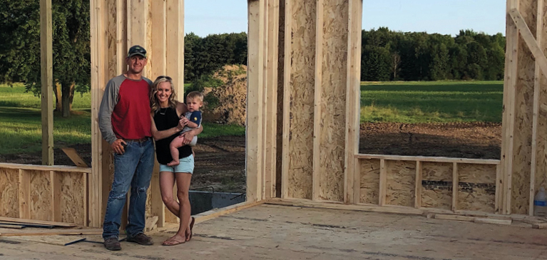 Jeff, Dawn, and their son Luke pose with their new house. 