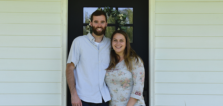 Adam Ford and Kelsey Ladley in front of their front door of their dream home