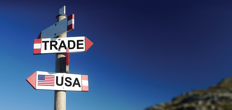 Clear blue skies behind wooden sign with arrows, one arrow pointing left labled USA and the arrow pointed right is labeled trade.