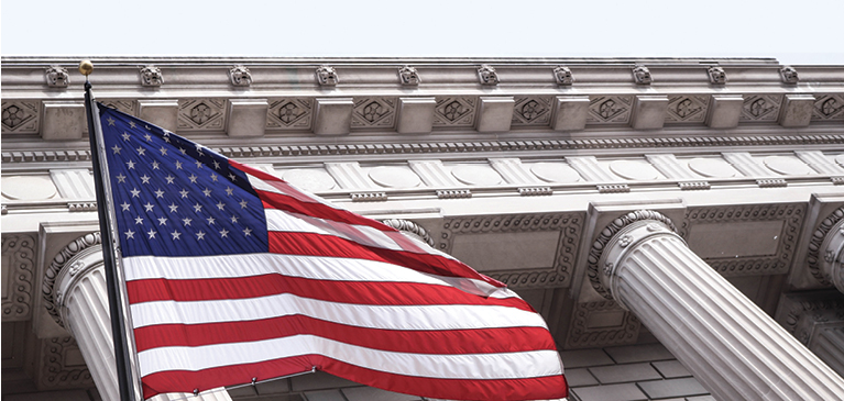 American flag waving underneath government building