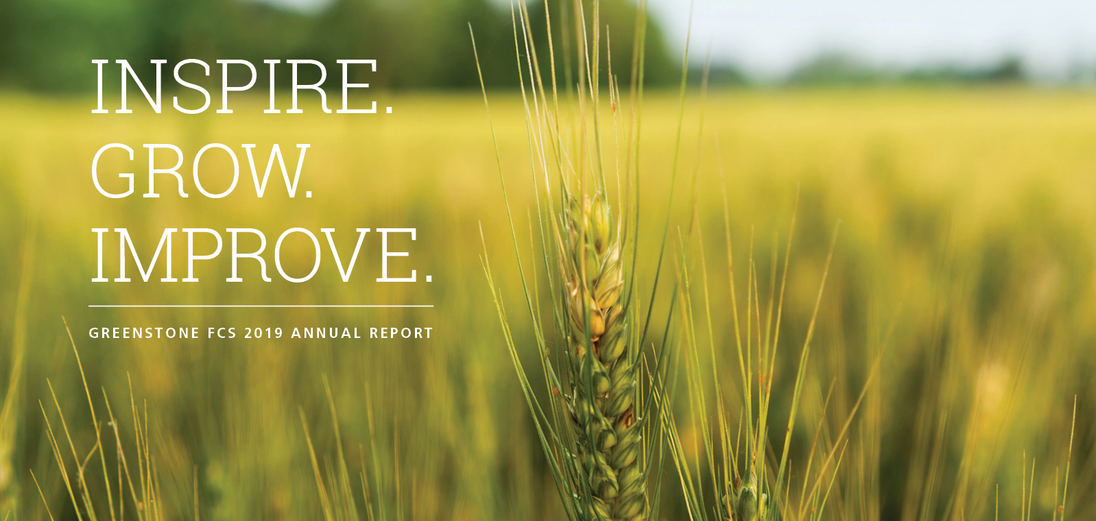 Inspire, Grow, Improve with a wheat field in the background.