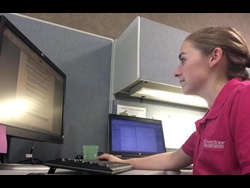 Abbey in front of the GreenStone sign at the Adrian branch
