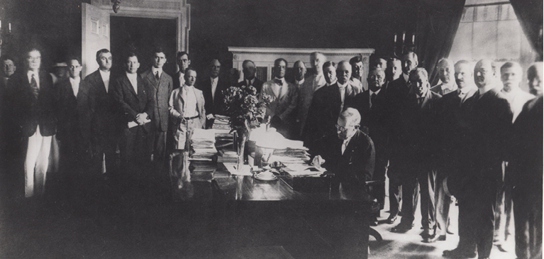 062916-commemorating-100-years-of-service President Woodrow Wilson signing federal legislation