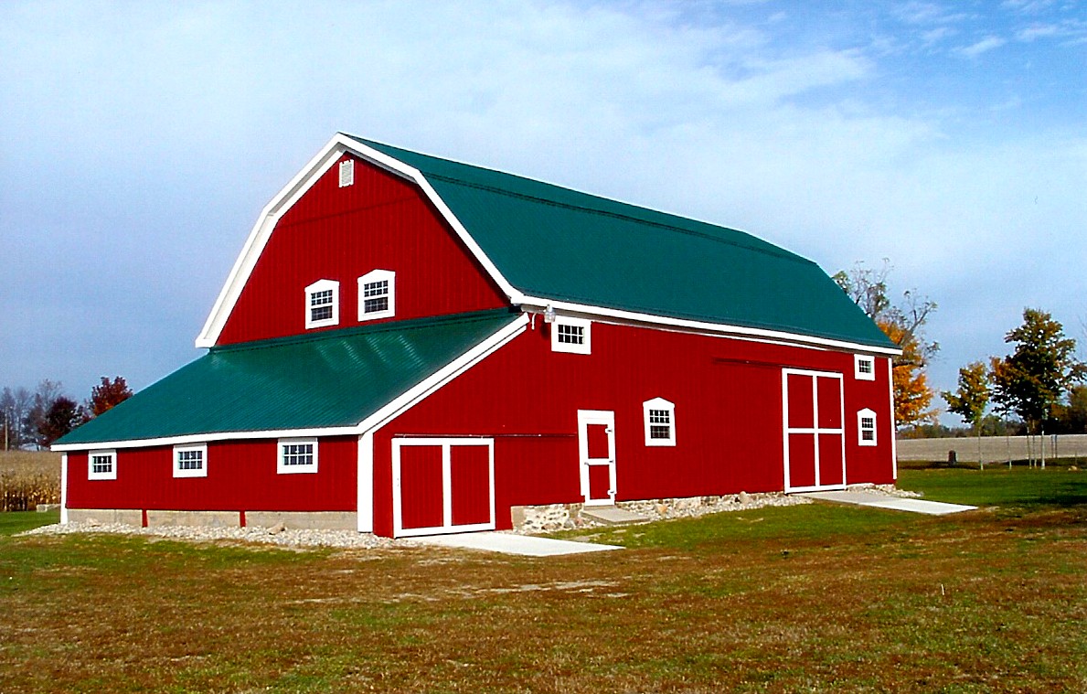 Large red barn with green metal roofing completely redone on farm for barn believers fund