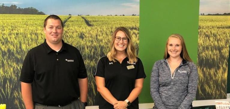 GreenStone employees, Scott Simon, Elana Fata and Gayle Giddings smile in front of the career fair display at a MSU job fair