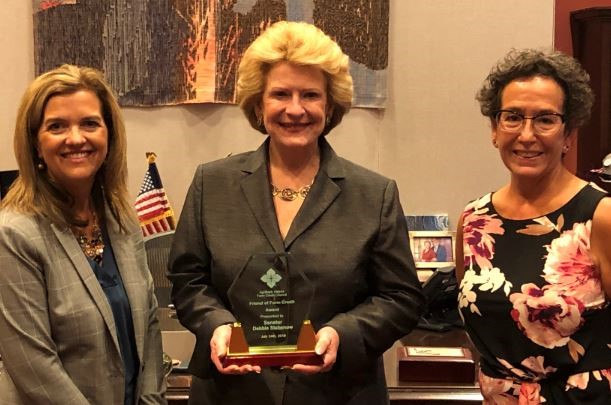 Senator Debbie Stabenow receives award, Friend of Farm Credit and is pictured with Christine Cumbraugh and Laura Braun