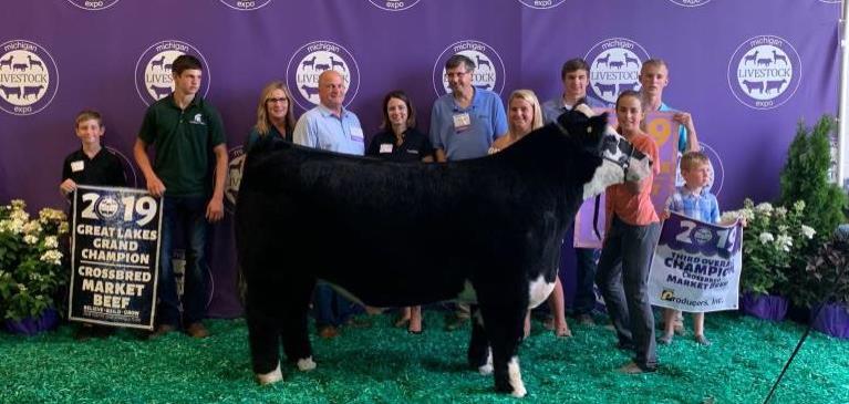 Emma Noll, winner of champion market beef with her steer and GreenStone employees.
