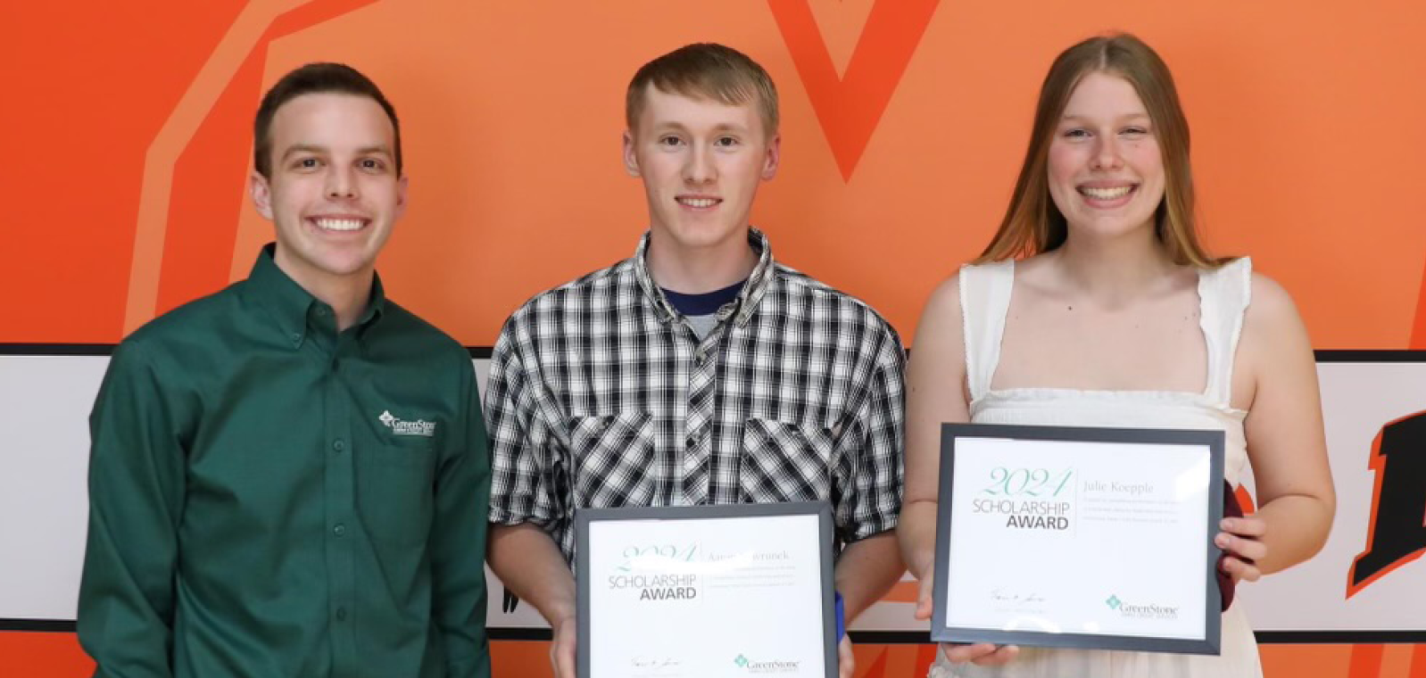 Two men and a woman with an award