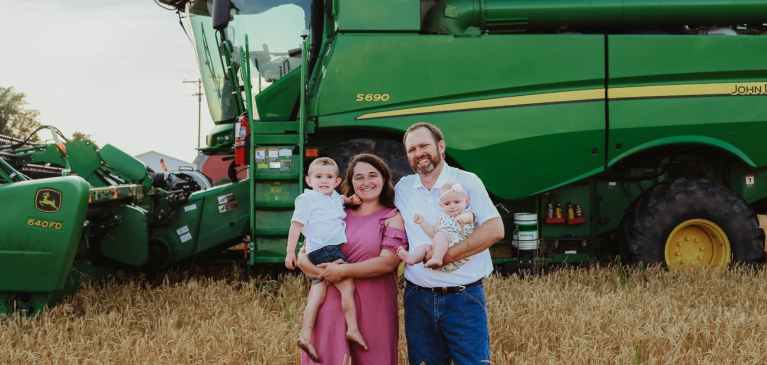The Chaffin family standing by combine.