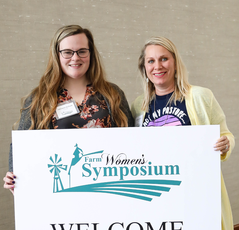 Farm Women's Symposium first time attendees- Adrianna Jackson and Colleen Russell  holding a welcome sign 