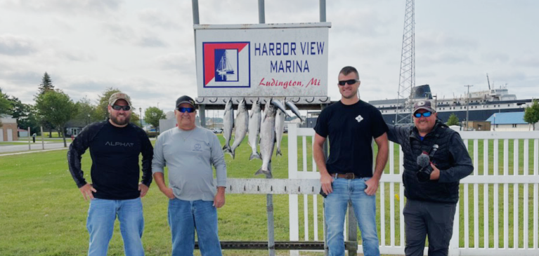 Charter Fishing Trip members at dock with fish