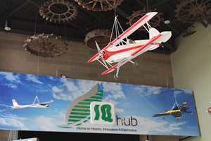 Large model airplane hanging from ceiling at AgroLiquid's IG Hub aviation exhibit.