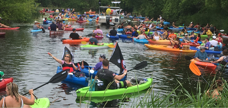 people in colorful kayaks floating in the river