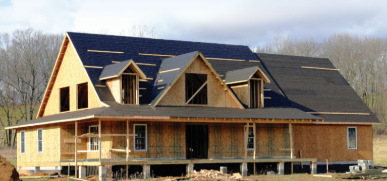 A two story house being built in the country on a clear sunny day with a GreenStone construction loan