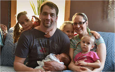 New Growth Family photo of couple holding new born baby and three young girls