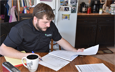 New Growth Man in kitchen farmhouse going over financials