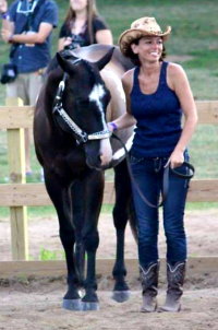 GreenStone employee, Rebecca Davis, standing in ring with her horse