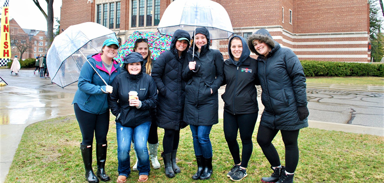 Members of the Sigma Alpha sorority standing under umbrellas at the 2019 5K Duck Race