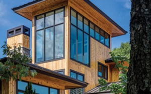 Surrounded by nature beautiful wooden house with large tower like windows