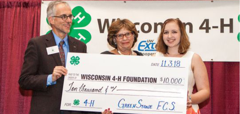 Three adults from Wisconsin 4H presenting a check