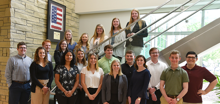 GreenStone's 2019 group of interns standing on stairs at the corporate office in East Lansing.