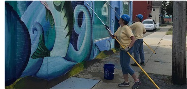 Two GreenStone employees clean an exterior wall
