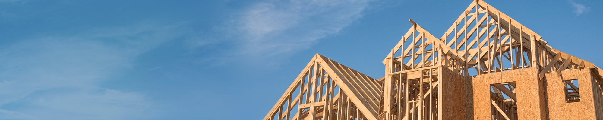 New home framing with a blue sky