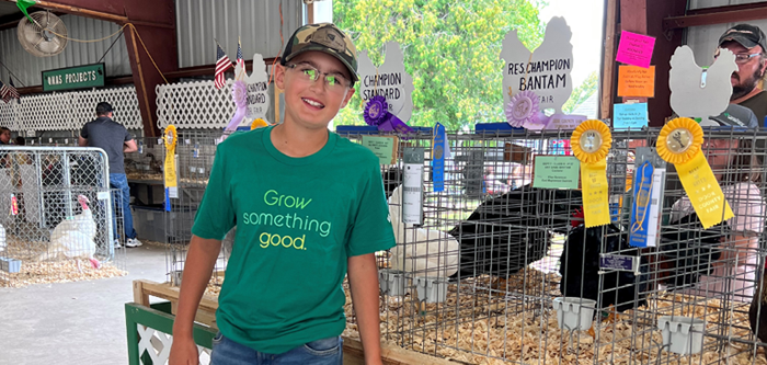Young boy standing next to his chicken at the fair