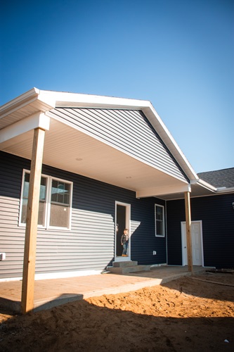 Little boy standing in the doorway of the house