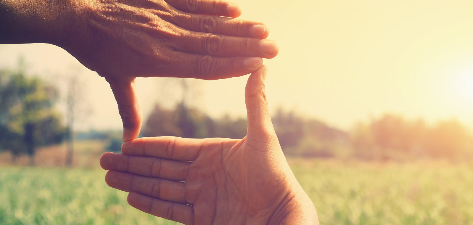 hands making a rectangle towards the sun