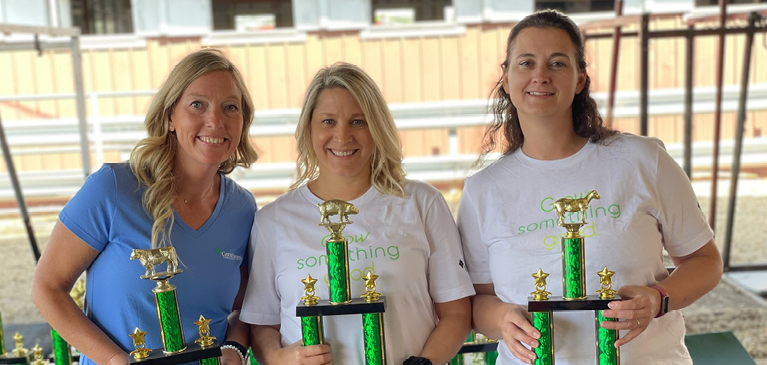 Three Women holding trophies