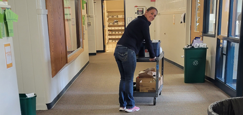 woman pushing a cart with popcorn bags