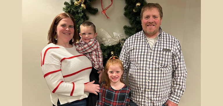 family of four standing for a picture