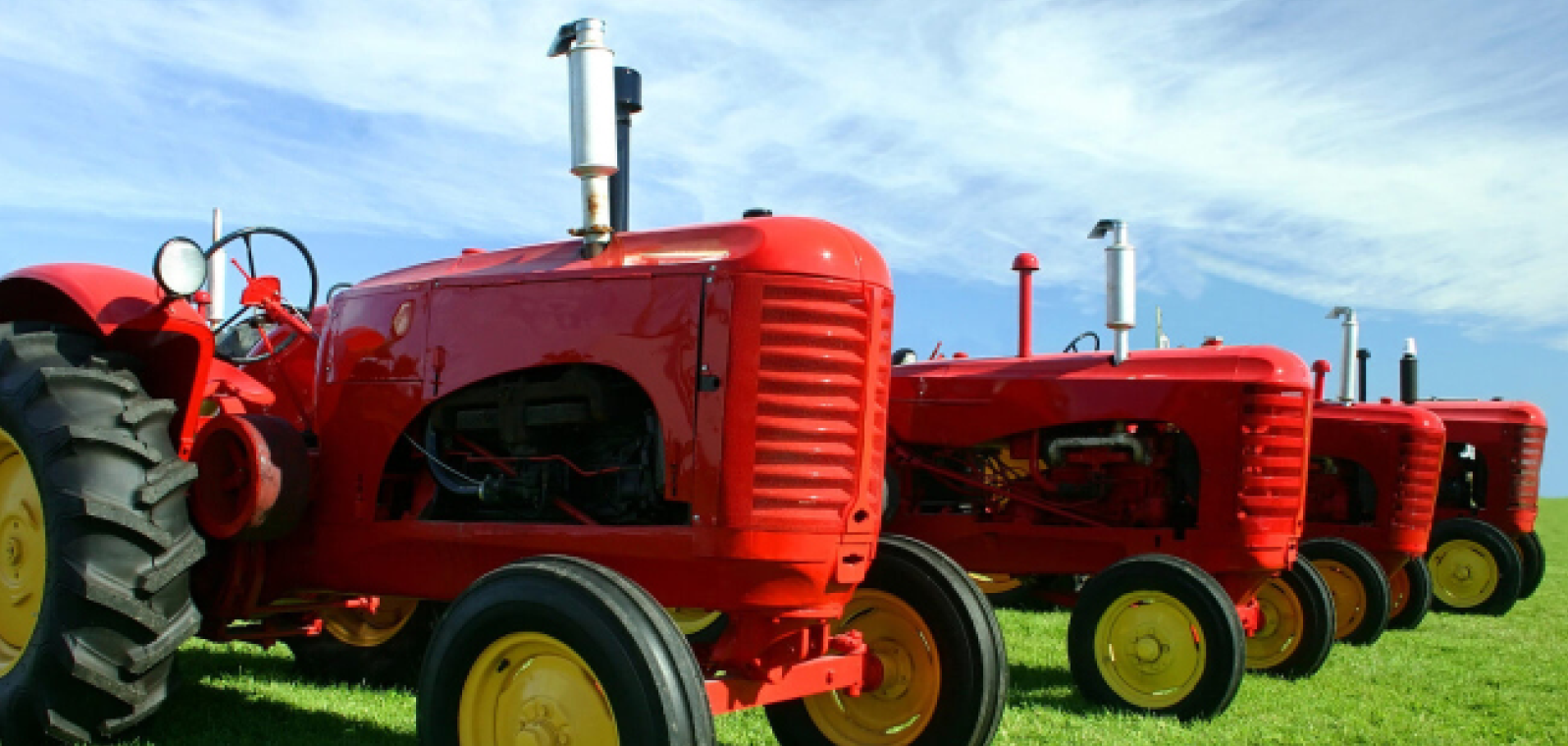 Four red tractors lined up