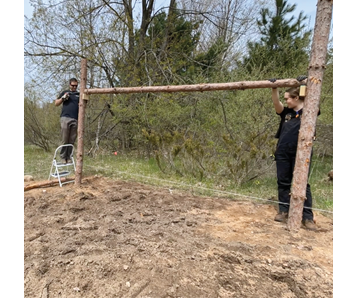 Two guys putting trellis poles up