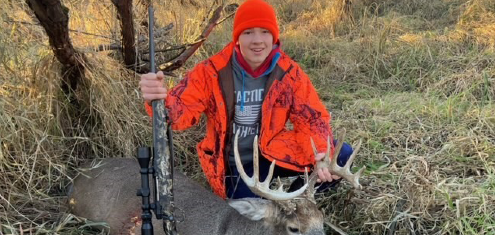 Kid holding up a deer