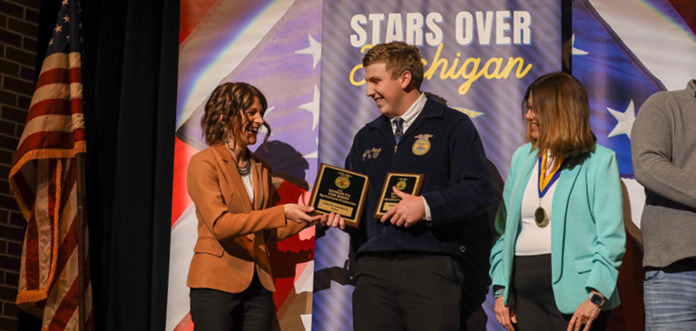 Man and woman shaking hands for award