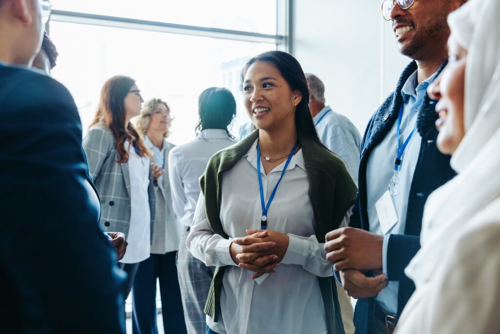 A woman in a group of other conference attendees all with access badges.
