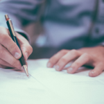 Person writing on a piece of paper
