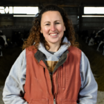 customer in barn with cows in background