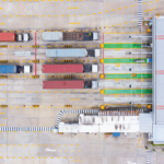 Eagle eye view of semi trucks pulling into a loading bay