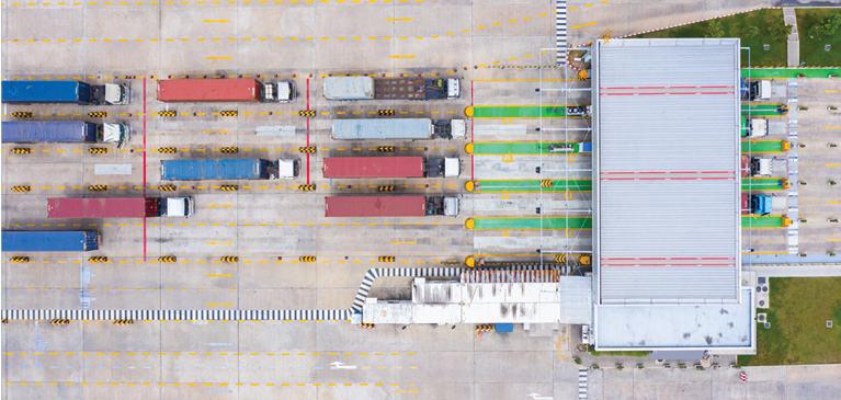 Eagle eye view of semi trucks pulling into a loading bay
