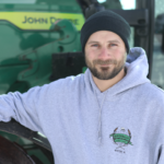Male farmer leaning on a tractor
