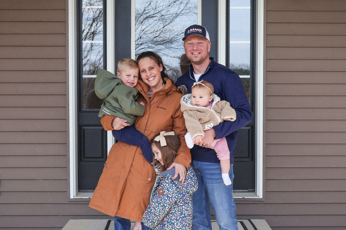 The Theilen family outside their new home