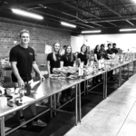 Students standing at a table smiling